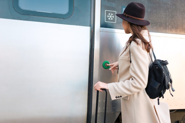 Woman presses button on the train door