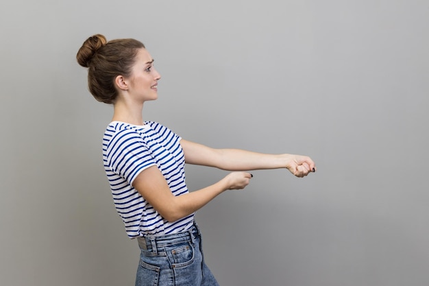 Photo woman pretending to pull invisible rope concept of hard working striving efforts to achievements