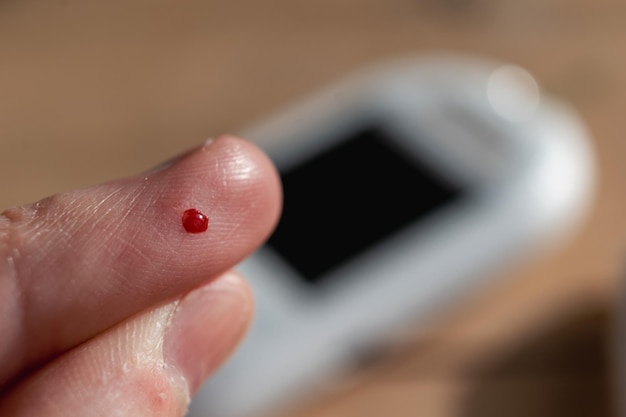 Woman pricking her finger to check blood glucose level with glucometer test blood glucose for diabetes