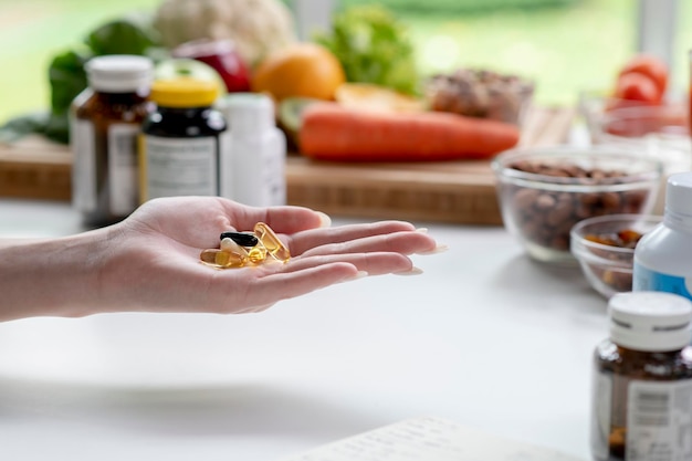 Woman professional nutritionist checking dietary supplements in hand surrounded by a variety of fruits nuts vegetables and dietary supplements on the table