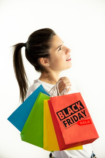 Woman in profile holding colorful bags on a white background shopping concept sales black friday christmas