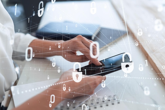 A woman programmer is browsing the Internet in smart phone to protect a cyber security from hacker attacks and save clients confidential data Padlock Hologram icons over the typing hands Formal wear