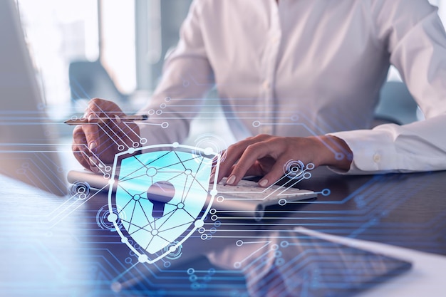 A woman programmer is typing a code on computer to protect a cyber security from hacker attacks and save clients confidential data Padlock Hologram icons over the typing hands Formal wear