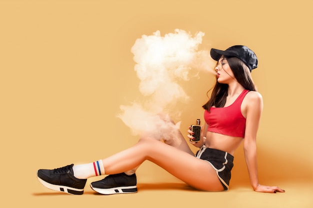 Woman puffing vapor on yellow