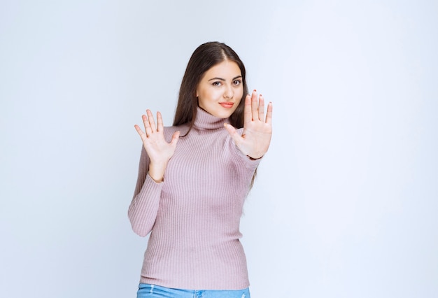 woman in purple shirt stopping something with hands.