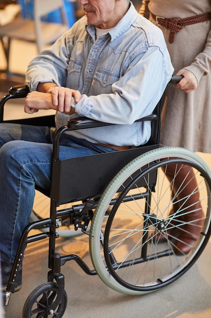 Woman pushing man in wheelchair