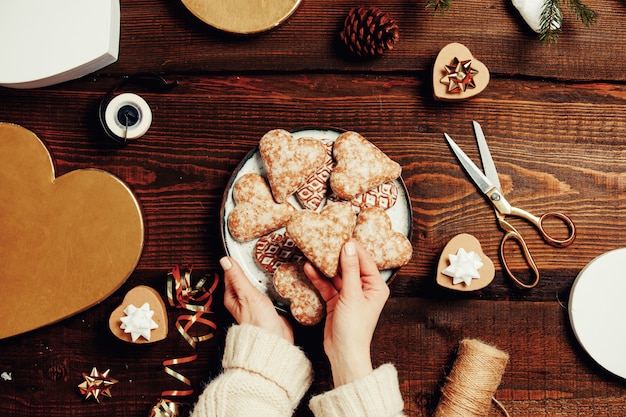 Woman put cookies in a box with gifts around