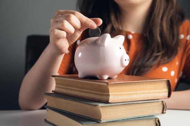 Woman puts coins in the piggy bank