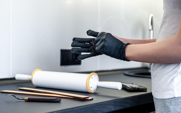 A woman puts on gloves in the kitchen kitchen work and hygiene