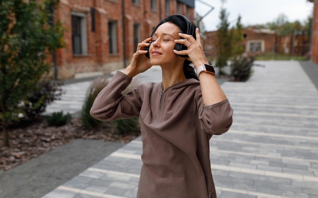 Woman puts on wireless headphones and enjoys songs and gets motivated