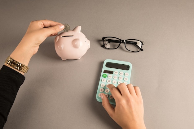 Woman putting a coin in a piggy bank