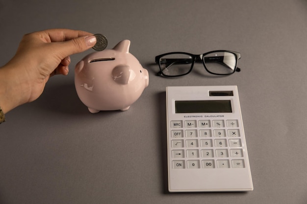 Woman putting a coin in a piggy bank