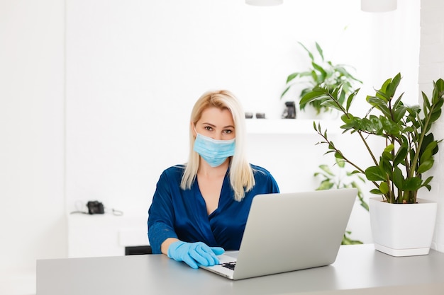 Woman in quarantine wearing protective mask and smart working