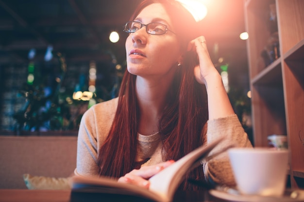 Woman reading a book in a cafe