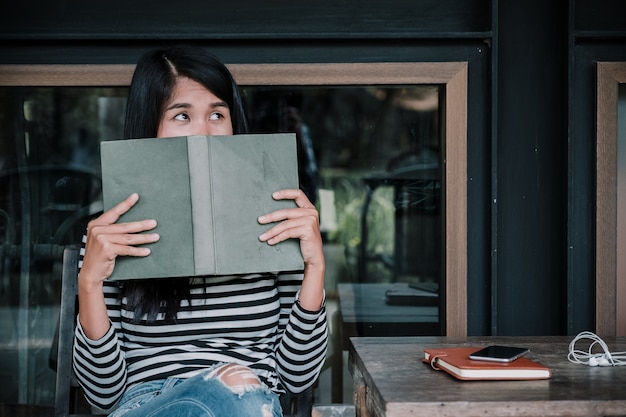 Woman reading a book and covering her face