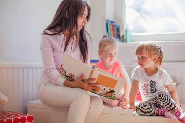 Woman reading book to girl