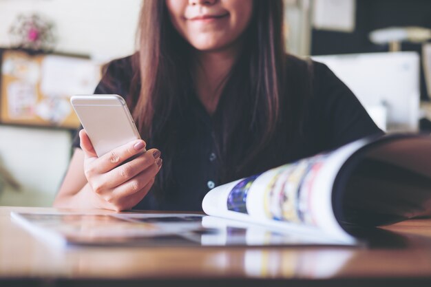 Woman reading a book and using smart phone