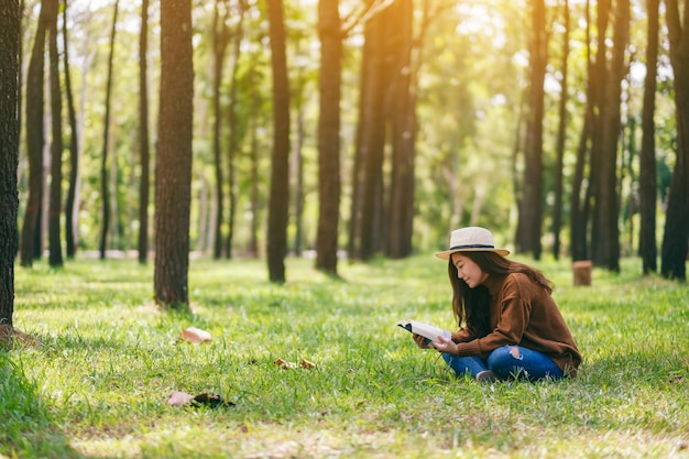 Woman reading book while sitting in forest