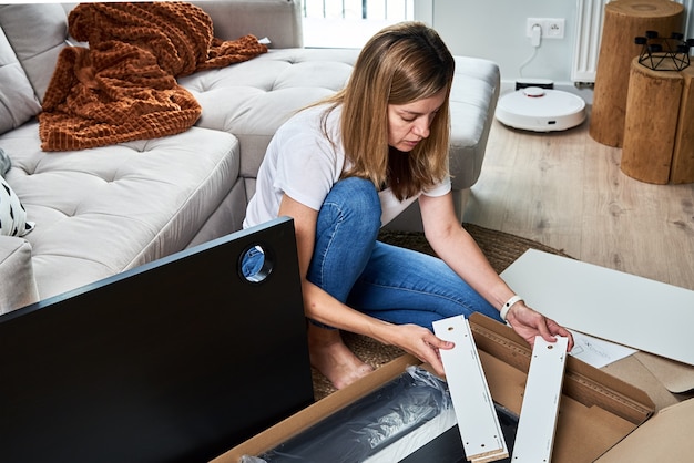 Woman reading manual instruction to assemble furniture