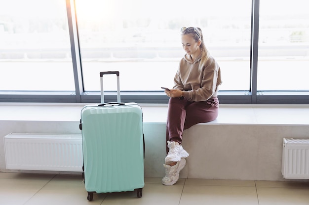 Woman reading a message while sitting at the airport