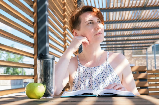 Woman reads a book near the office during a work break