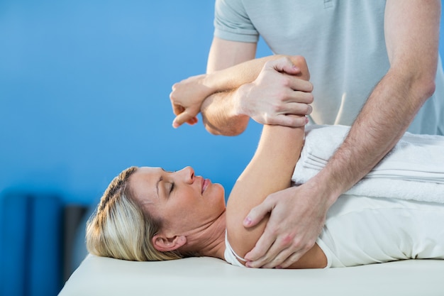 Woman receiving shoulder therapy from physiotherapist