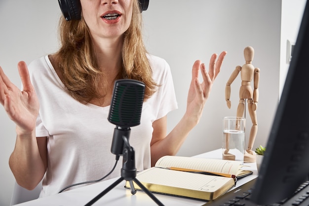 Woman recording online podcast at home, podcasting concept