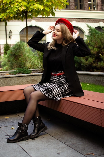 A woman in a red beret sits on a bench