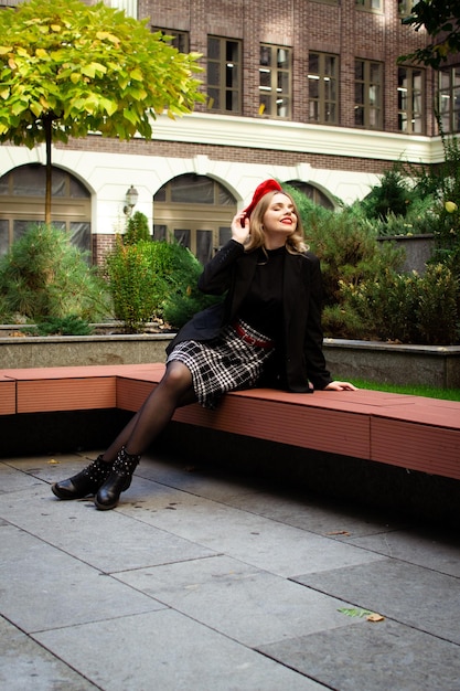 A woman in a red beret sits on a bench