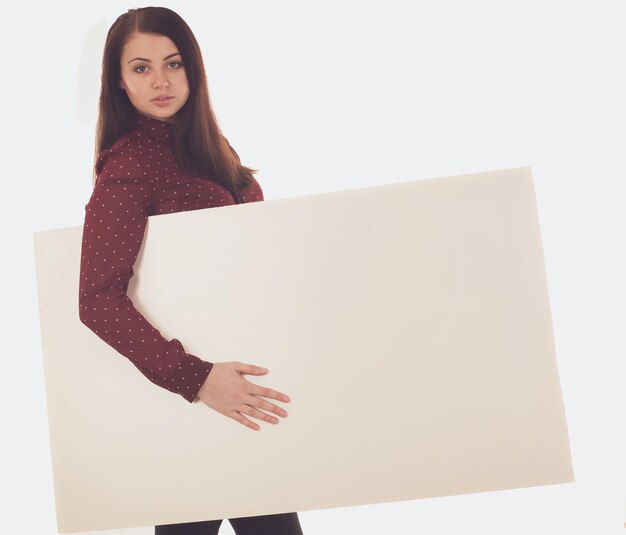 Woman in red blouse is holding a blank canvas