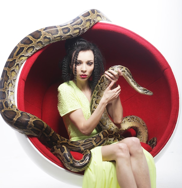 Woman in red chair holdung python