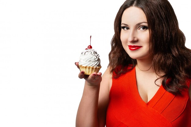 A woman in a red dress holding a cake 