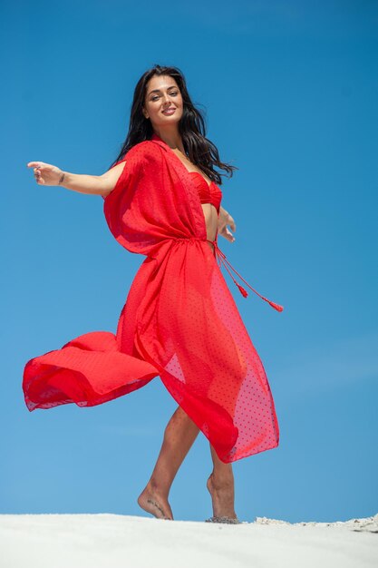 A woman in a red dress is dancing in the air.