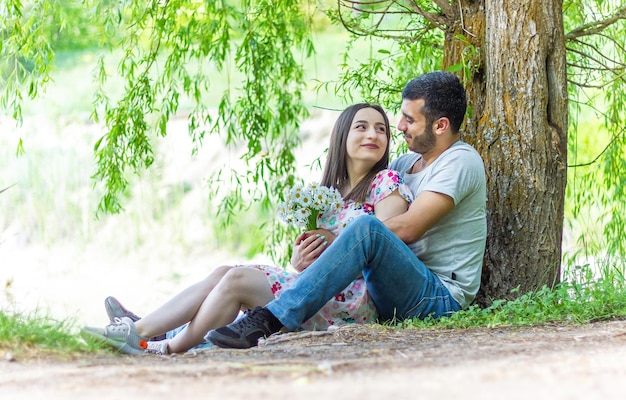 woman in red dress with boyfriend in the park young couple in the park