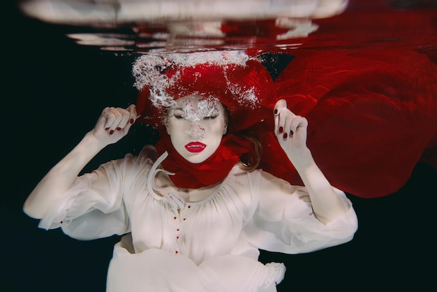 Woman in red hat and red scarf underwater