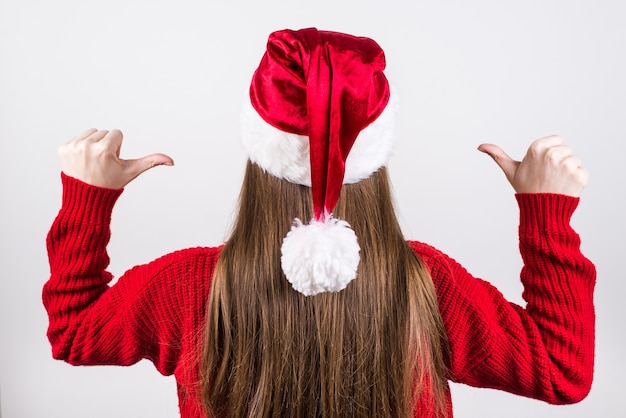 Woman in red jumper and santa hat showing fingerts on herself