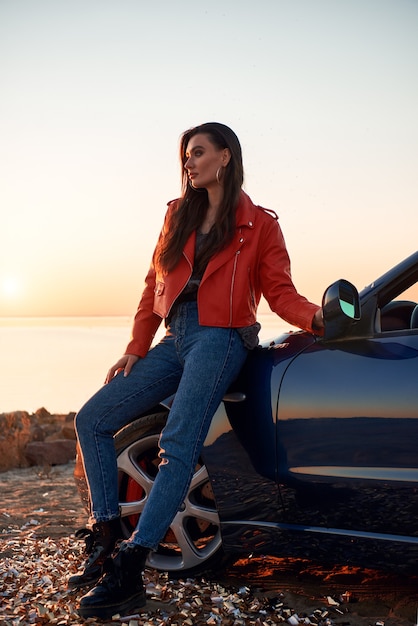 Woman in red near cabriolet she wearing sunglasses