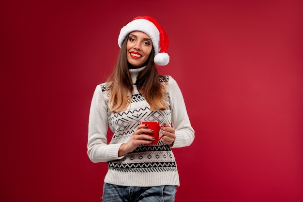 Woman in red Santa hat on red