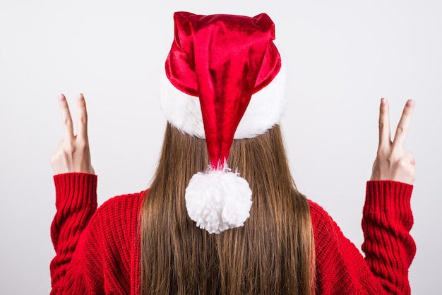 Woman in red santshat gesturing double v-sign