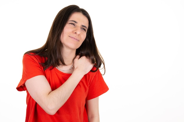 Woman in red shirt in pain having headache hand on shoulder