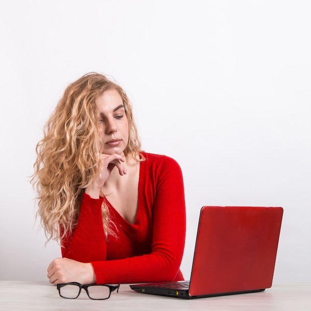 woman in red, working remotely at the computer on white.