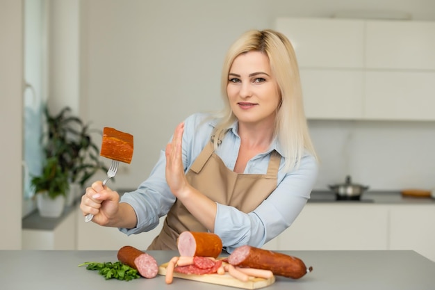 woman refuses sausage on a fork