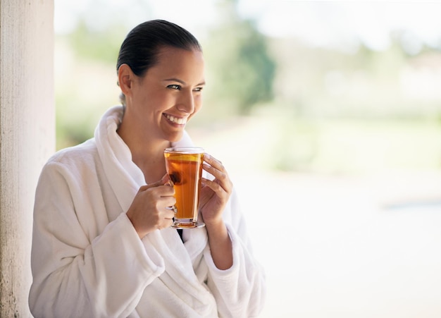 Woman relax and happy at spa with herbal tea on holiday break and luxury for mindfulness Female person resort and smile with healthy drink on vacation trip and travel for wellness at hotel