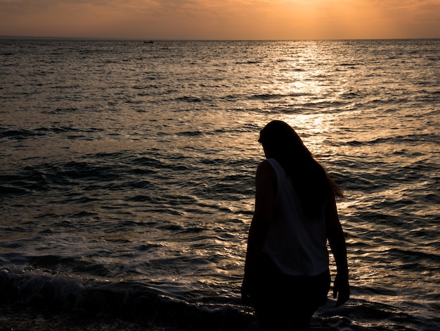 Woman relaxing at the beach during beautiful sunset. Vacation human relaxation