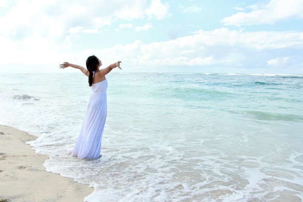 Woman relaxing at the beach with arms open