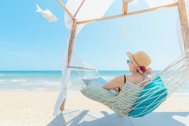 Woman relaxing in hammock on the beach