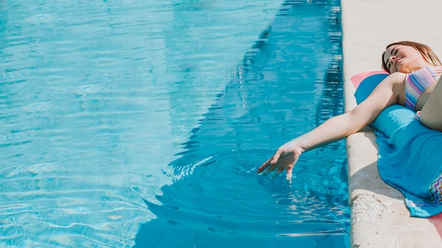 Woman relaxing next to pool