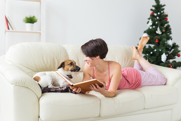 Woman relaxing on the sofa with her cute dog