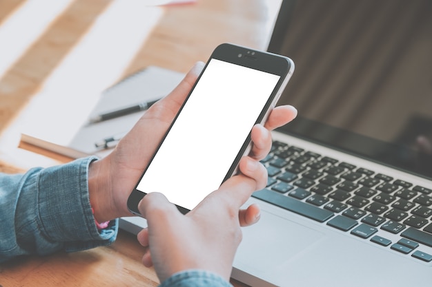 Woman relaxing while using smartphone blank screen for graphics display 