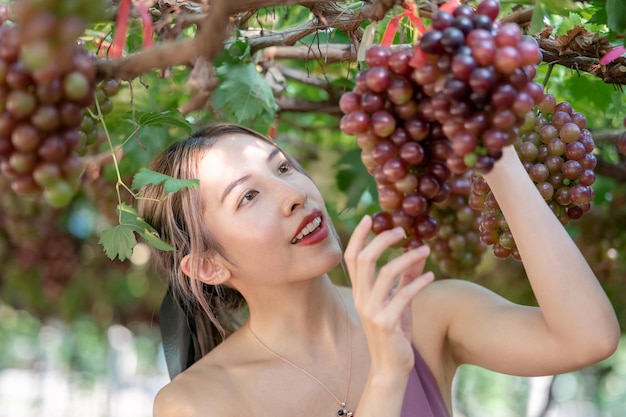 Woman relaxing with nature, grapes in vineyard.